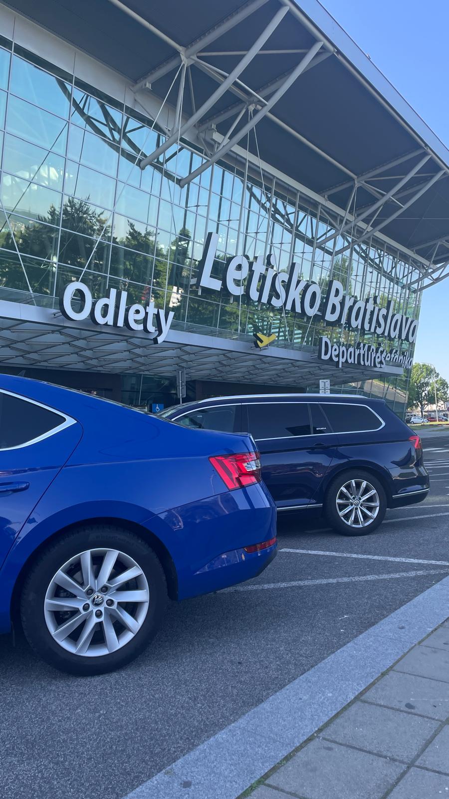 Dve vozidlá GETLIMO zaparkované pred letiskom v Bratislave – pripravené na odvoz alebo príjazd klientov.